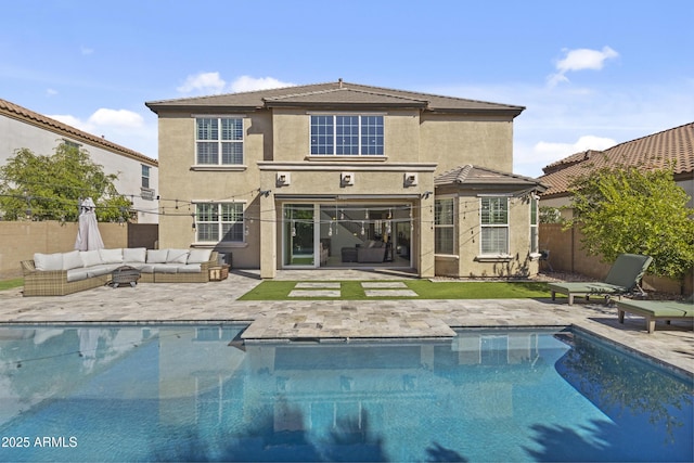 rear view of house with a patio, a fenced in pool, an outdoor living space, a fenced backyard, and stucco siding