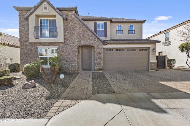 view of front of property with a garage, decorative driveway, stone siding, and stucco siding