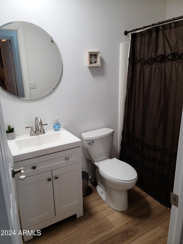 bathroom featuring vanity, hardwood / wood-style flooring, toilet, and walk in shower