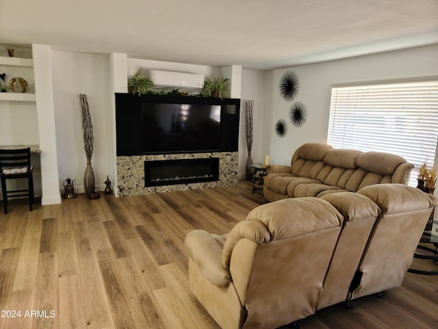 living room with a wall unit AC and light hardwood / wood-style floors