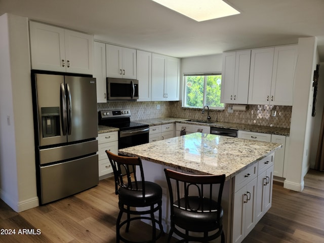 kitchen featuring a kitchen island, white cabinets, and appliances with stainless steel finishes