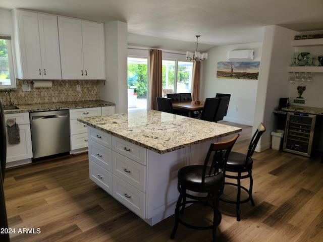 kitchen featuring white cabinetry, a wall mounted AC, beverage cooler, a center island, and stainless steel dishwasher