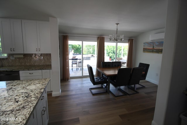 dining area featuring an AC wall unit, a notable chandelier, and dark hardwood / wood-style flooring