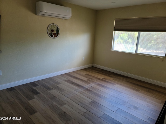 unfurnished room featuring light hardwood / wood-style floors and an AC wall unit