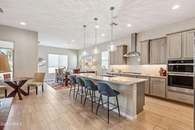19045 N 269th Dr, Buckeye, AZ 85396 - kitchen featuring wall chimney range hood, a sink, stainless steel appliances, plenty of natural light, and recessed lighting