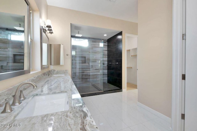 bathroom featuring a shower with door and vanity