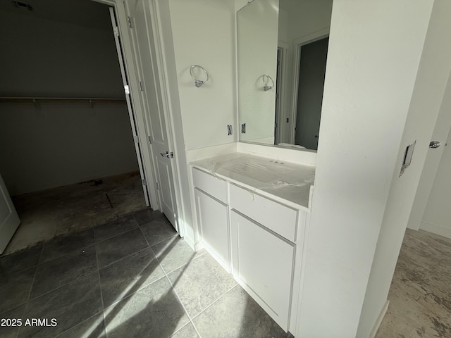 bathroom featuring vanity and a walk in closet