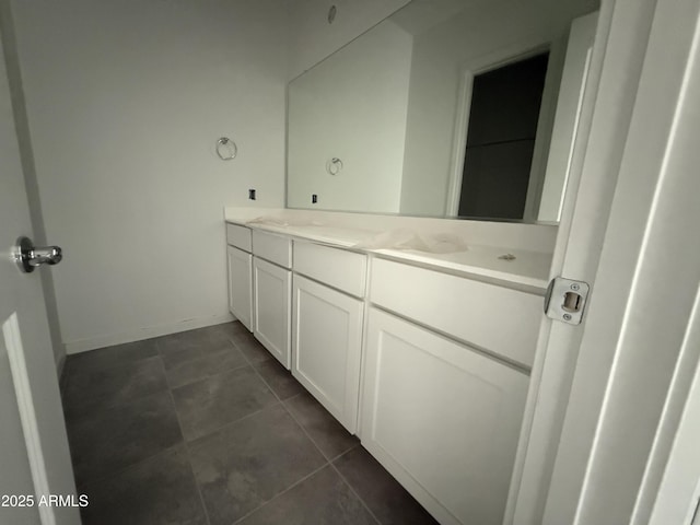 bathroom with baseboards and double vanity