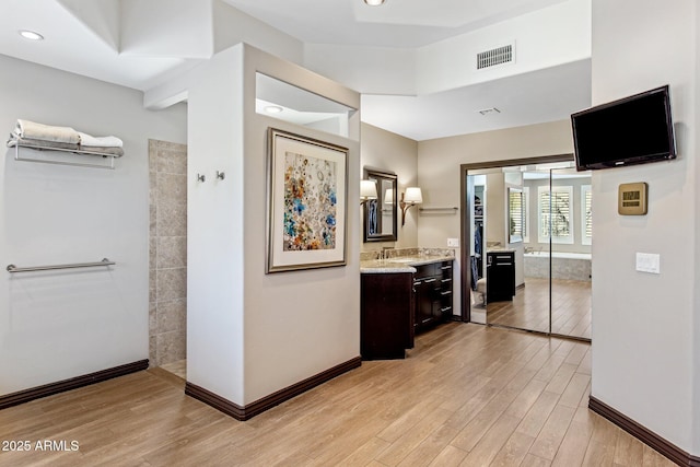 hallway featuring sink and light hardwood / wood-style floors