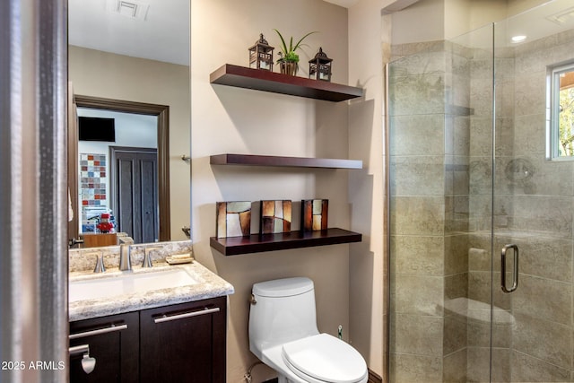 bathroom featuring vanity, toilet, and an enclosed shower