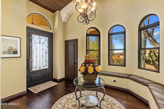 foyer with high vaulted ceiling, a notable chandelier, and dark hardwood / wood-style flooring