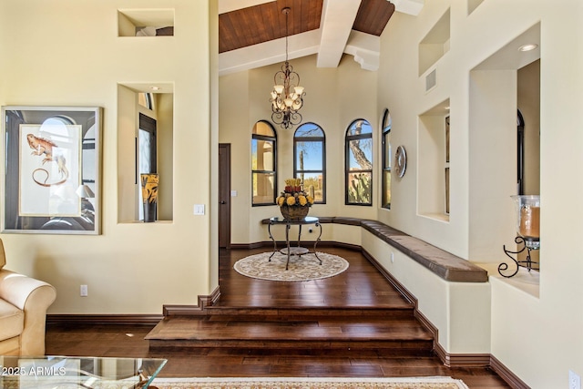 interior space with beamed ceiling, high vaulted ceiling, an inviting chandelier, and dark hardwood / wood-style flooring