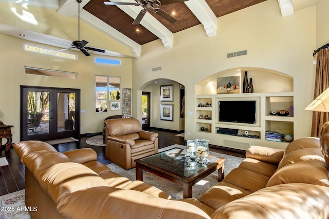 living room with beam ceiling, hardwood / wood-style floors, built in shelves, and french doors