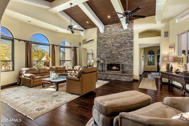 living room featuring beamed ceiling, a fireplace, dark hardwood / wood-style flooring, and high vaulted ceiling