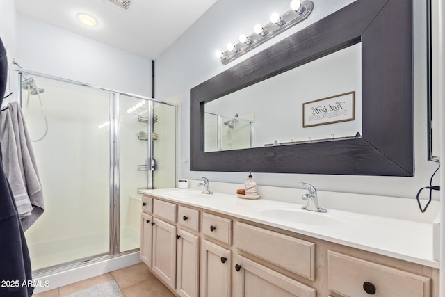 bathroom featuring tile patterned floors, a shower with door, and vanity