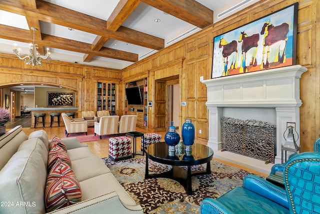 living room with coffered ceiling, a notable chandelier, wooden walls, and beam ceiling