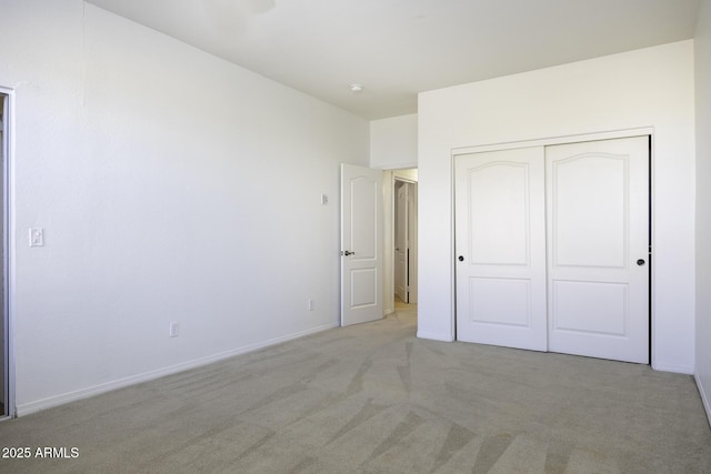 unfurnished bedroom with light carpet and a closet