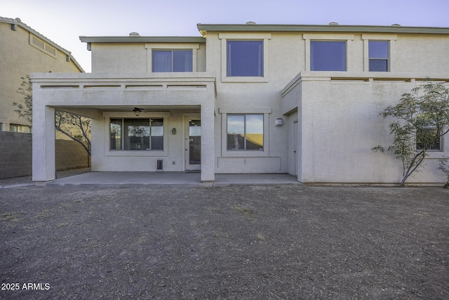 rear view of house featuring ceiling fan and a patio