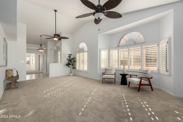 carpeted living room with ceiling fan and vaulted ceiling