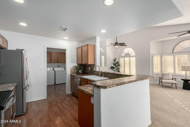 kitchen featuring sink, washer and dryer, appliances with stainless steel finishes, kitchen peninsula, and ceiling fan