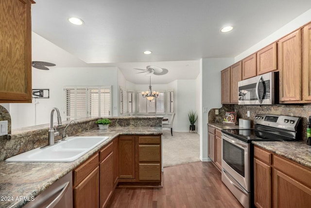 kitchen featuring sink, tasteful backsplash, decorative light fixtures, appliances with stainless steel finishes, and dark hardwood / wood-style flooring