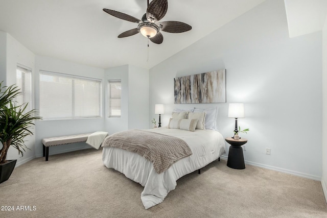 bedroom with multiple windows, vaulted ceiling, light colored carpet, and ceiling fan