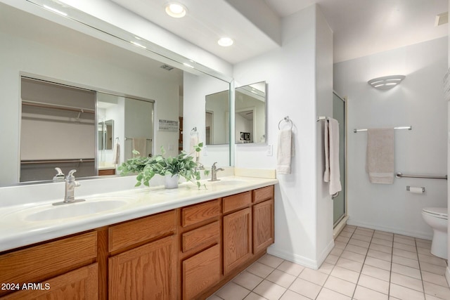 bathroom with walk in shower, vanity, toilet, and tile patterned flooring