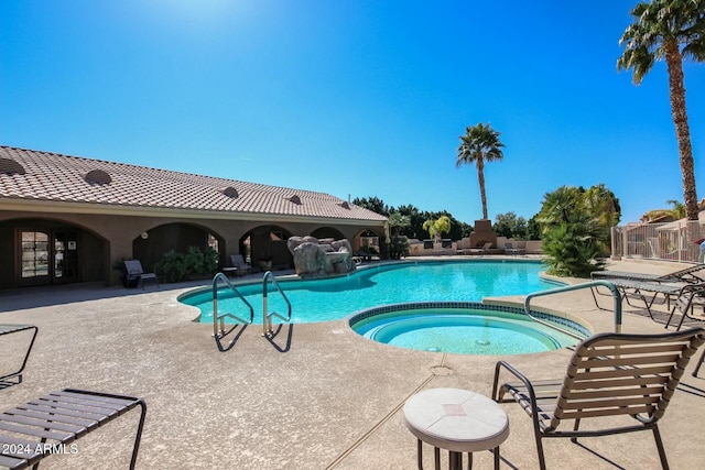 view of pool featuring a community hot tub and a patio area