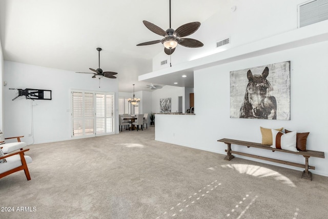 carpeted living room with lofted ceiling and ceiling fan with notable chandelier