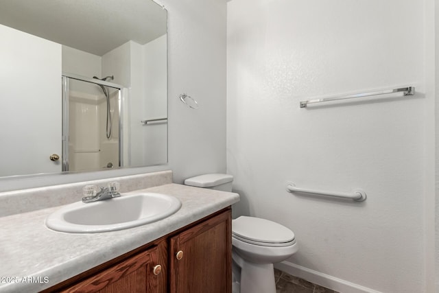 bathroom featuring vanity, tile patterned flooring, a shower with door, and toilet