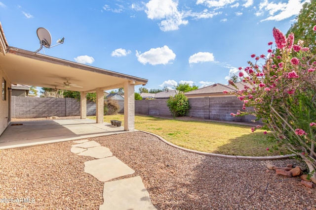 view of yard featuring ceiling fan and a patio