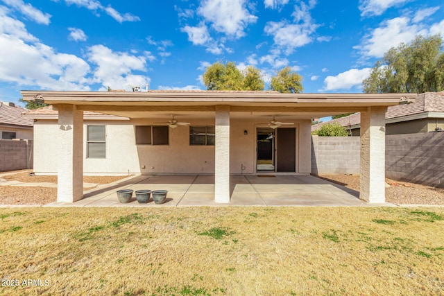 rear view of property with a patio, a yard, and ceiling fan