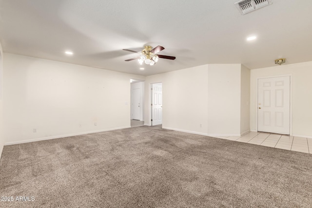 spare room featuring light carpet and ceiling fan