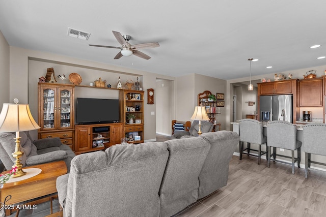 living room with ceiling fan and light hardwood / wood-style flooring