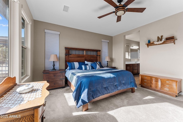 carpeted bedroom featuring connected bathroom and ceiling fan