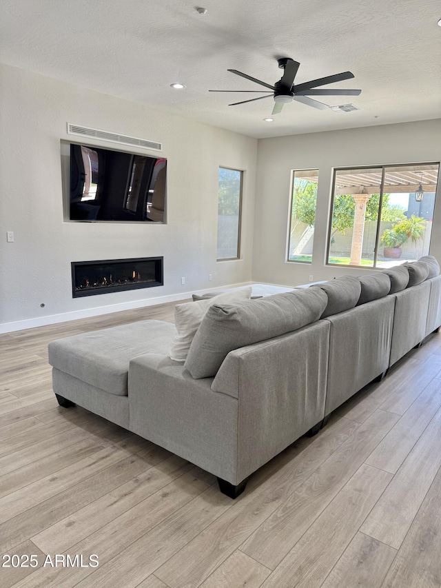 living room featuring ceiling fan and light hardwood / wood-style floors