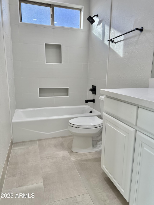 full bathroom with tile patterned floors, tiled shower / bath combo, vanity, and toilet