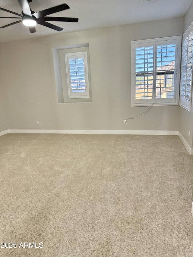 carpeted spare room featuring ceiling fan