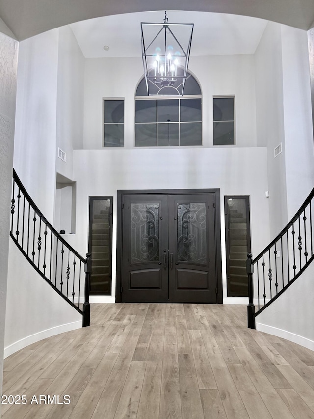 entrance foyer with a chandelier, a high ceiling, and light hardwood / wood-style flooring