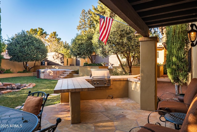 view of patio with area for grilling and a grill