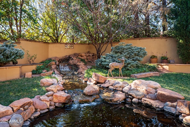 view of yard featuring a garden pond