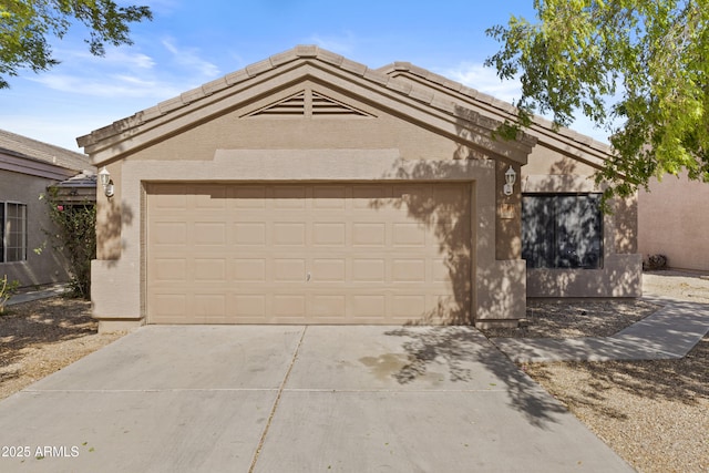 view of front facade with a garage, concrete driveway, a tiled roof, and stucco siding