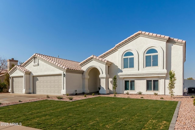 mediterranean / spanish-style house with a garage and a front lawn