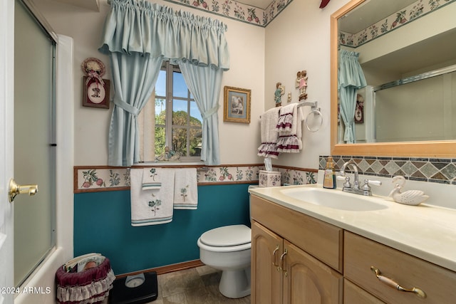 full bathroom with vanity, enclosed tub / shower combo, and toilet