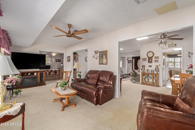 carpeted living room with a textured ceiling and ceiling fan