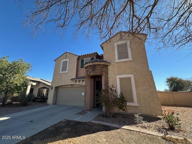 mediterranean / spanish house with a garage, fence, driveway, and stucco siding