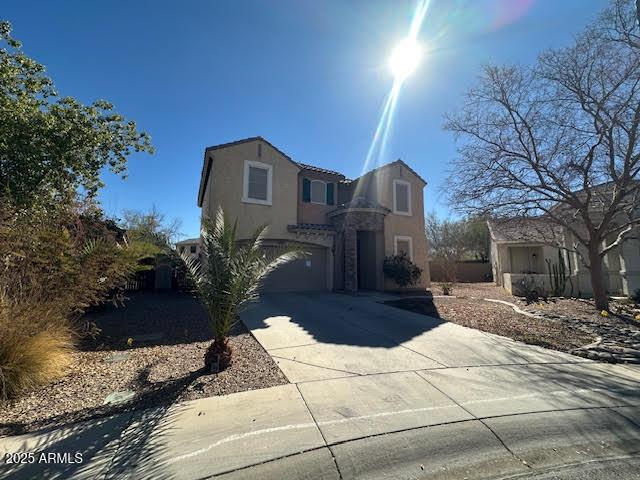 view of front of house featuring driveway, a garage, and stucco siding