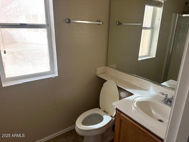 bathroom with toilet, a wealth of natural light, and vanity