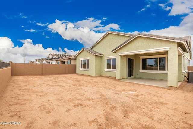 rear view of house with central AC and a patio area