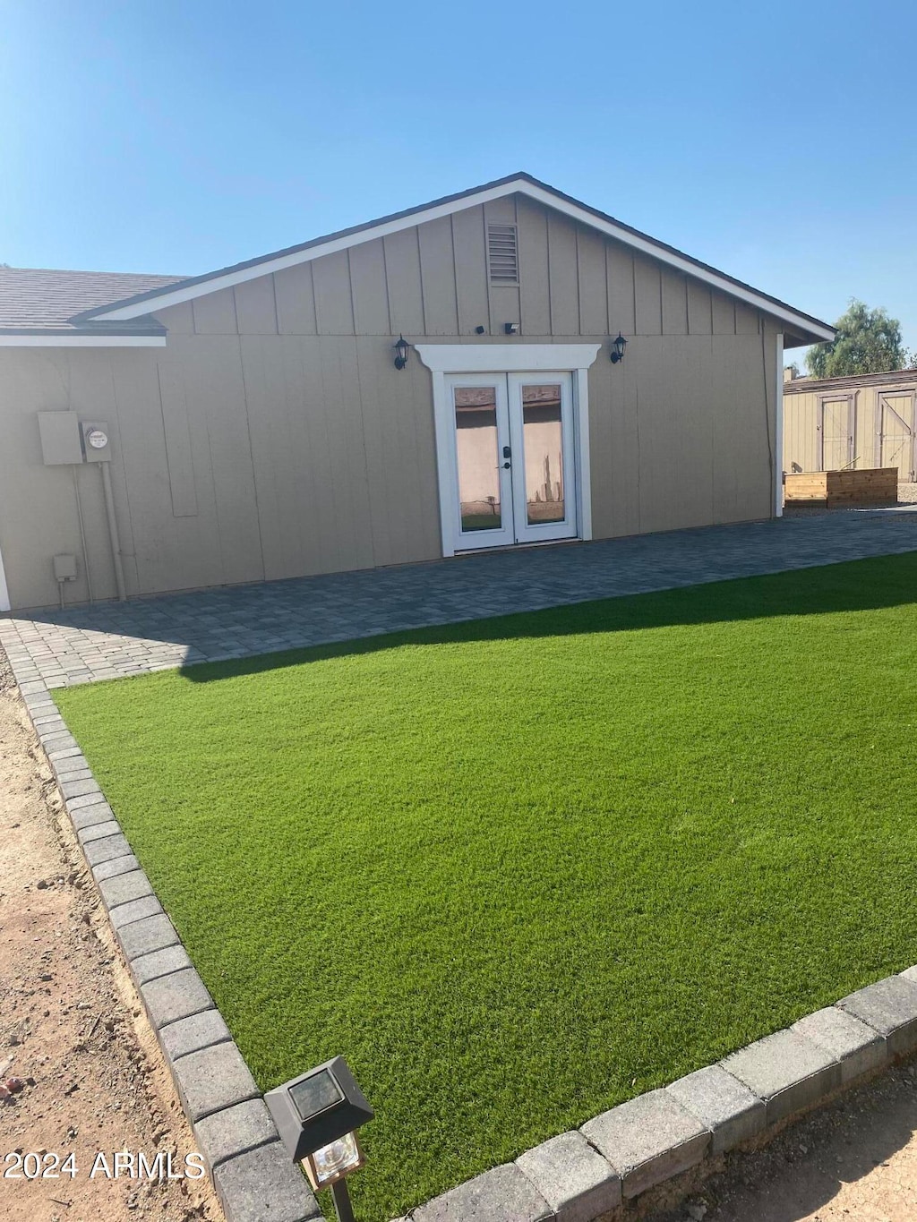 exterior space with french doors and a lawn